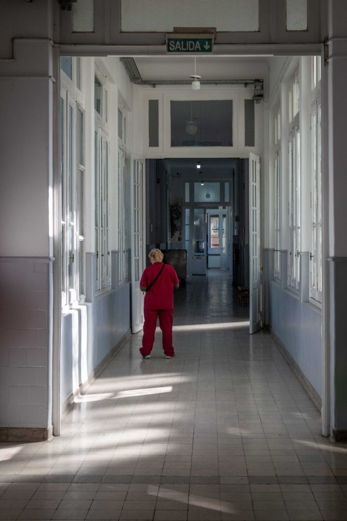 Paciente caminando por un pasillo hospitalario tras una intervención de columna