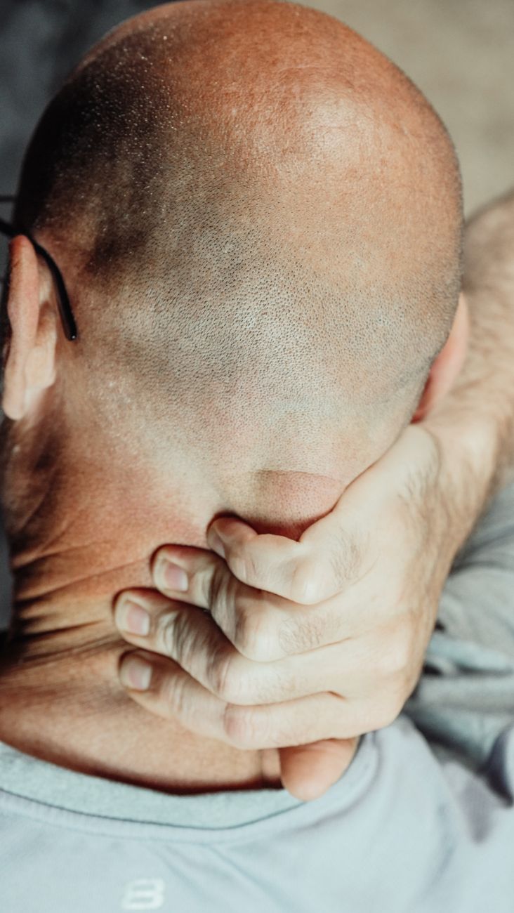 Dolor cervical con la mano apoyada en la nuca